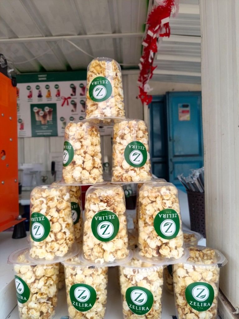 Tumpukan cup popcorn bermerek Zelira Tea House di booth